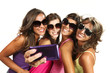 Four girls  taking pictures of themselves through cell phone