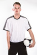 Fußballer mit Fußball und Fußballtrikot und Hose