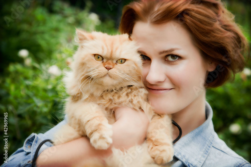 Photo: Young woman with Persian cat playing Young woman with Persian cat playing