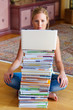 Studentin mit einem Stapel Bücher und Computer