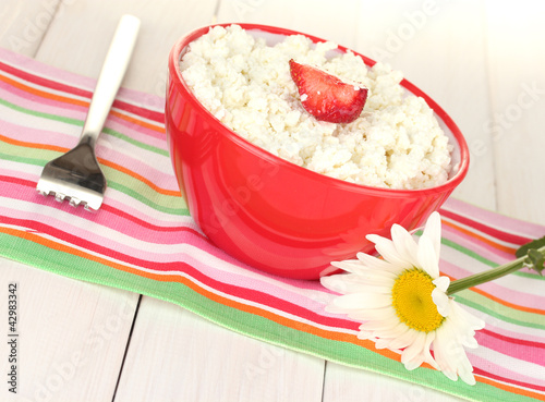 Foto: cottage cheese with strawberry in red bowl, fork and flower cottage cheese with strawberry in red bowl, fork and flower