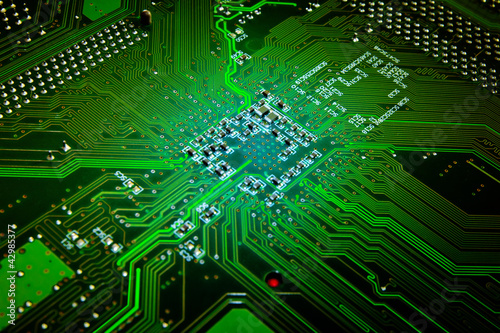 Photo: Green glowing computer motherboard abstract background Green glowing computer motherboard abstract background