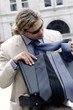 A man in business suit and sunglasses choosing a suitable tie