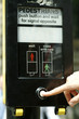 A hand pressing the traffic light button before crossing