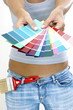 A woman in jeans showing colour cards