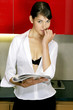 Sexy woman biting finger while reading a magazine 