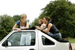 Three women posing on a car