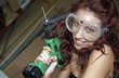 Woman with goggles holding a drill 