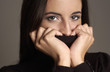 Woman covering her mouth with her turtle neck blouse 