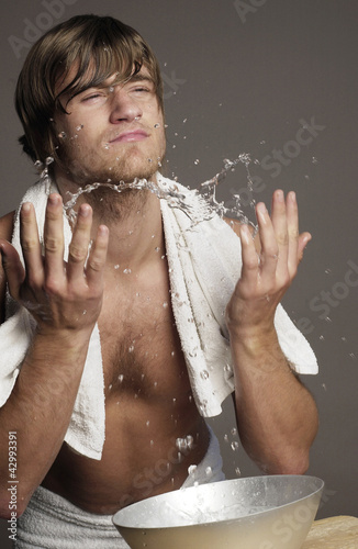 Photo: Shirtless man splashing water onto his face Shirtless man splashing water onto his face