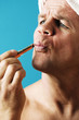 Man applying lipstick