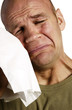 Man wiping his tears with a tissue