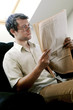 Photo: Bespectacled man reading newspaper Bespectacled man reading newspaper
