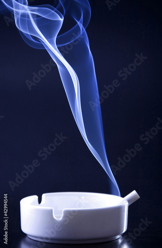 Photo: Blue cigarette smoke in black background Blue cigarette smoke in black background