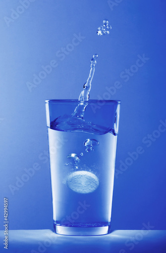 Photo: Soluble pill dropping into a glass of water Soluble pill dropping into a glass of water