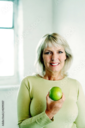 Photo: Woman holding a green apple Woman holding a green apple