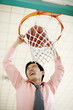 Businessman dunking basketball