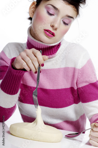 Photo: Woman holding fork and spoon with dough on the table Woman holding fork and spoon with dough on the table