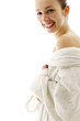 Woman in white bathrobe smiling at the camera