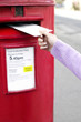 Hand putting a letter into the post box