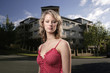 A teenage girl posing in front of buildings
