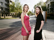 Two teenage girls posing in front of buildings