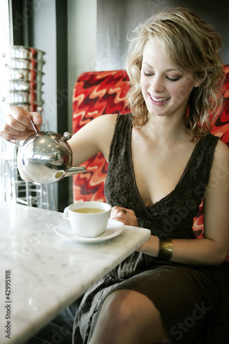 Photo: A teenage Caucasian girl enjoying her tea in the cafe A teenage Caucasian girl enjoying her tea in the cafe