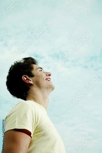 Photo: Young man laughing while looking up Young man laughing while looking up