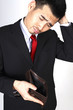 Photo : Businessman scratching his head while looking at his empty wallet Businessman scratching his head while looking at his empty wallet