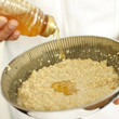 Hand pouring honey into the ingredients for beauty treatment