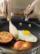 Frying egg and tomatoes