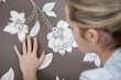 Woman checking wallpaper's texture