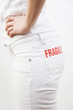 Woman with the word 'fragile' on her white jeans