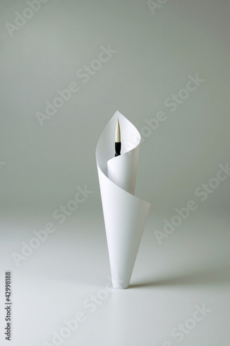 Photo: Paper wrapping around a painting brush Paper wrapping around a painting brush