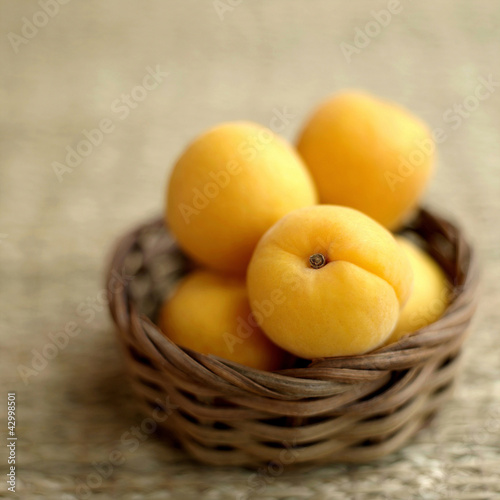 Photo: Close up of some apricots in a woven container Close up of some apricots in a woven container