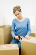 Woman sealing up boxes