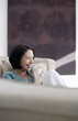 Woman sitting on the couch enjoying a cup of coffee
