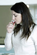 A woman sipping cough syrup