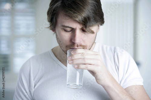 Photo: A man drinking a glass of effervescence A man drinking a glass of effervescence