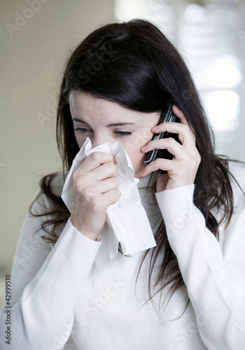 Photo: A woman with cold on the phone A woman with cold on the phone