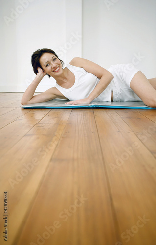 Photo: Woman lying on yoga mat Woman lying on yoga mat