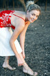 Woman smiling at the camera while adjusting her high heel