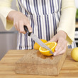 Woman's hands cutting orange