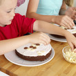 Boy and girl decorating cakes with chocolate candies