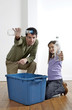 Man and girl holding up plastic bottles to be recycled
