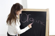 Photo : Girl writing the word 'Organic' on the blackboard Girl writing the word 'Organic' on the blackboard