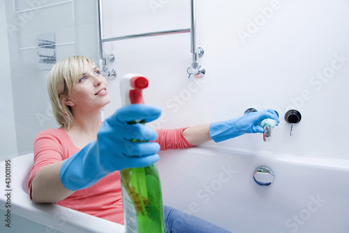 Photo: Woman sitting in the bathtub after cleaning the bathroom Woman sitting in the bathtub after cleaning the bathroom