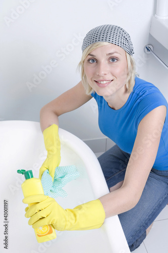 Photo: Woman with rubber gloves cleaning the bathtub Woman with rubber gloves cleaning the bathtub