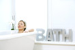 Photo: Woman listening to music while resting in bathtub Woman listening to music while resting in bathtub