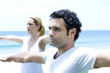 Man and woman practising yoga, arms outstretched